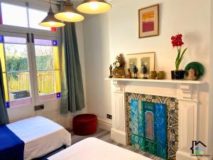 - une chambre avec une cheminée et un lit dans l'établissement Cambridge Stays 3BR house, easy walk to city center, 2 showers, garden, 2 free parking spaces, à Cambridge
