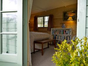 ein Schlafzimmer mit einem Bett und einem Bücherregal in der Unterkunft The Lodge On The Marsh in Brading