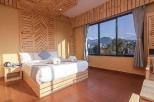 um quarto com uma cama grande e uma janela grande em Trekkers Inn Boutique Hotel Pokhara em Pokhara