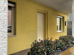 a yellow building with a door and two windows at Luxury Apartment Treviso and Venice in Treviso