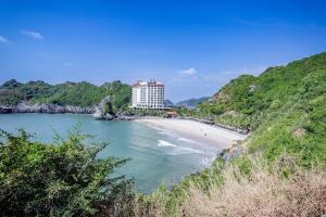 vistas a una playa con un edificio a lo lejos en Ngoc Linh Cat Ba Hotel, en Cat Ba