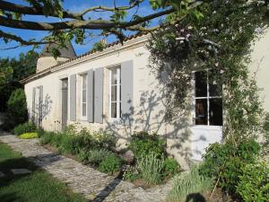 a white house with a garden in front of it at Le Moulin de la Borderie in Saint-Pierre-dʼOléron