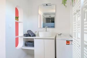 un bagno con lavandino e specchio di Le petit mannevillettais a Mannevillette