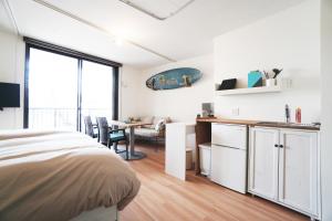 Higashi-nada-ekiNADA Terrace的一间带床的卧室和一间带桌子的厨房