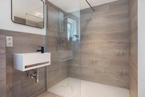 a bathroom with a sink and a shower at Villa Wiesenau by Restaurant WIESENAU in Prerow +29 photos