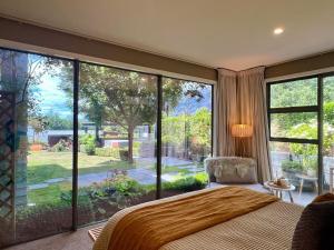 a bedroom with a large window and a large bed at 5-Star Boutique Retreat! Hot pool! Amazing view! in Queenstown
