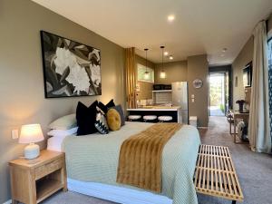 a bedroom with a large bed and a kitchen at 5-Star Boutique Retreat! Hot pool! Amazing view! in Queenstown