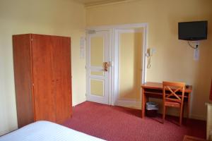 - une chambre avec un lit, un bureau et une télévision dans l'établissement Grand Hotel De La Gare, à Évreux