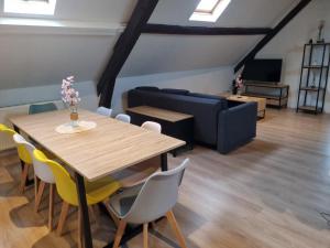 a living room with a table and chairs and a couch at Appart'hotel SOLESMES in Solesmes