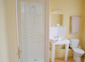 Baño blanco con aseo y lavamanos en Grand Hotel De La Gare, en Évreux