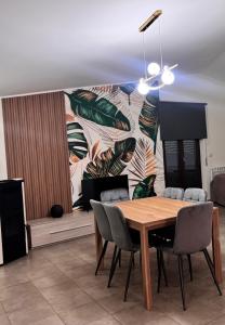 una sala da pranzo con tavolo e sedie e un murale di B&B Golden House & spa a Rose