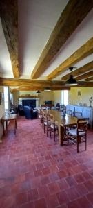 Un comedor con mesa y sillas y chimenea. en La longère du golf, en Verneuil-sur-Indre
