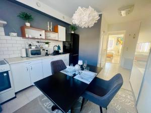 a kitchen with a black table and chairs in it at Alpesi Apartman Downtown in Sopron