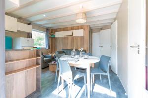 a kitchen and a dining room with a table and chairs at Camping le Marache in Biganos