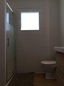 a bathroom with a toilet and a window at Villa MA&VA in Lacanau-Océan