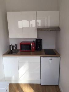 a small kitchen with a red microwave on a counter at Villa MA&VA in Lacanau-Océan