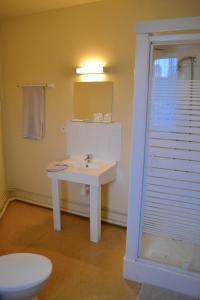 a bathroom with a white sink and a toilet at Grand Hotel De La Gare in Évreux