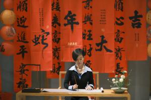 a woman sitting at a table in front of a table at Yangshuo Zen Garden Resort - Rich Chinese traditional activities in Yangshuo