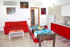 a living room with a table and a red couch at Ariel Apartment Ortigia Siracusa in Siracusa
