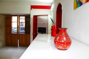 un jarrón rojo sentado en un mostrador en una habitación en Ariel Apartment Ortigia Siracusa, en Siracusa