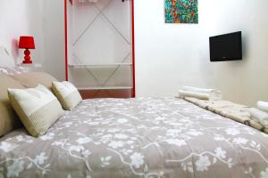 シラクーサにあるAriel Apartment Ortigia Siracusaのベッドルーム1室(大型ベッド1台、壁掛けテレビ付)