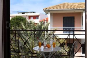 einen Tisch mit Gläsern Orangensaft auf dem Balkon in der Unterkunft Niriides in Lefkada Town