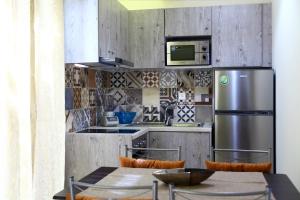 a kitchen with a refrigerator and a table with chairs at Niriides in Lefkada