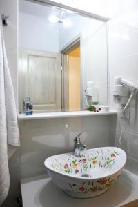 ein weißes Badezimmer mit Waschbecken und Spiegel in der Unterkunft Niriides in Lefkada Town