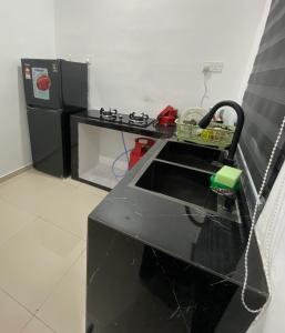 a kitchen with a black counter and a sink at homestay d klebang besar in Kelebang Besar