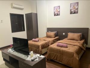 a room with two beds and a desk with a computer at Homestay Bayou Lagoon Resort & Waterpark, Free Access to Waterpark 2 pass in Kampong Bukit Beruang