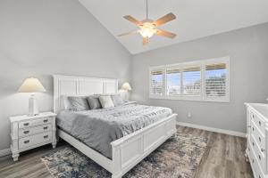 Un dormitorio blanco con una cama y un ventilador de techo. en Blessed by the Sea - Crescent Beach - Free Daily Activities home, en Crescent Beach
