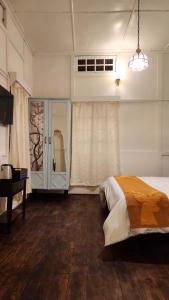 a bedroom with a bed and a table and a window at Rococo by Concordia Hospitality in Shillong