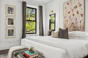 a white bedroom with a large bed and a window at The Perfect Apt for Large Groups Sleeps 10 in New York