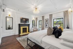 a white bedroom with a bed and a fireplace at The Perfect Apt for Large Groups Sleeps 10 in New York +39 photos