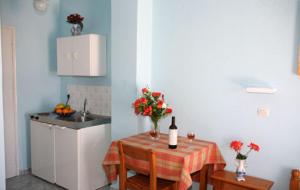 a kitchen with a table with a bottle of wine at Studio Mary in Perissa +12 photos