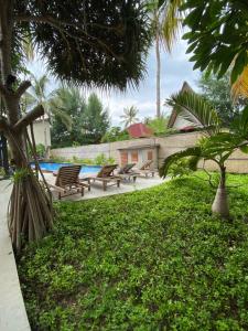 einen Hof mit Bänken und einem Pool in der Unterkunft Sama Sama Bungalows in Gili Trawangan