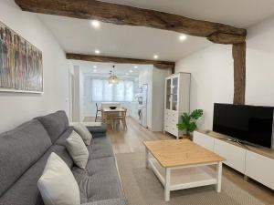 un soggiorno con un divano grigio e un tavolo di Bidebarrieta Etxea , apartamento recién reformado a Bermeo