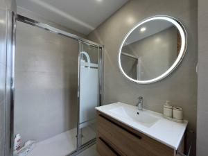 un bagno con doccia, lavandino e specchio di Bidebarrieta Etxea , apartamento recién reformado a Bermeo Altre 35 foto