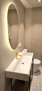 クレサーレにあるFriedrich Magnus, Güldenstubbe Residencesの洗面台、鏡、トイレ付きのバスルーム