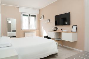 a bedroom with a bed and a desk and a tv at Dieci by Comorooms in Como