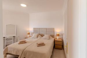 a white bedroom with a large bed and two lamps at Sunset Flower Apt By Dream Homes Tenerife in Puerto de Santiago
