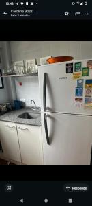 a white refrigerator in a kitchen with a sink at Pinamar para 5 a 100 metros del mar con garage in Pinamar