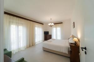 a bedroom with a white bed and some windows at Casa Pitara - apartment in vila in San Martino in Colle