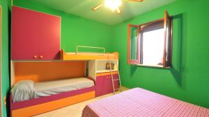 a childs room with a bunk bed and green walls at Villetta Giulia by Salento Affitti in Torre San Giovanni Ugento