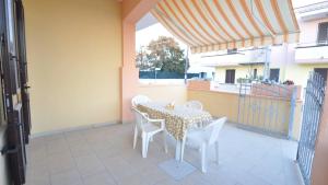 a table and chairs on a patio with a balcony at Villetta Giulia by Salento Affitti in Torre San Giovanni Ugento