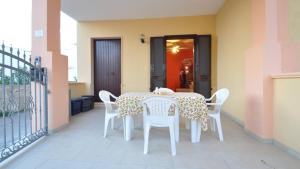 a table and chairs on the balcony of a house at Villetta Giulia by Salento Affitti in Torre San Giovanni Ugento