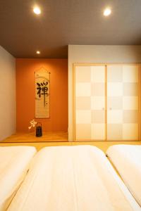 a bedroom with two beds and an orange wall at Hisaya-Totoya-A in Kyoto