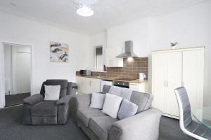 Una sala de estar con un sofá y sillas y una cocina. en Pepsi Max 2 Bed Apartment close to Pleasure Beach, en Blackpool 13 fotos más