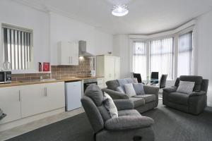 Una sala de estar con dos sillas y una cocina. en Pepsi Max 2 Bed Apartment close to Pleasure Beach, en Blackpool