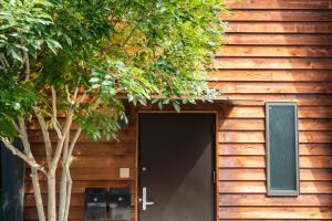 a door to a building with a tree at Hisaya-Totoya-A in Kyoto